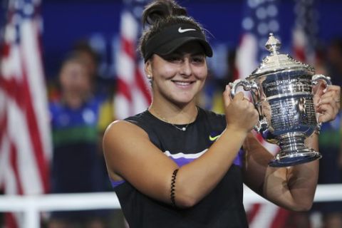 Bianca Andreescu, of Canada, holds up the championship trophy after defeating Serena Williams, of the United States, in the women's singles final of the U.S. Open tennis championships Saturday, Sept. 7, 2019, in New York. (AP Photo/Charles Krupa)