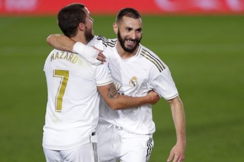 Real Madrid's Karim Benzema, right, celebrates with his teammate Eden Hazard after scoring his side's opening goal during the Spanish La Liga soccer match between Real Madrid and Valencia at Alfredo di Stefano stadium in Madrid, Spain, Thursday, June 18, 2020. (AP Photo/Manu Fernandez)