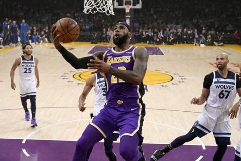 Los Angeles Lakers forward LeBron James, center, goes up for a shot as Minnesota Timberwolves guard Derrick Rose, left, forward Taj Gibson, second from right, and forward Andrew Wiggins watch during the first half of an NBA basketball game Wednesday, Nov. 7, 2018, in Los Angeles. (AP Photo/Mark J. Terrill)