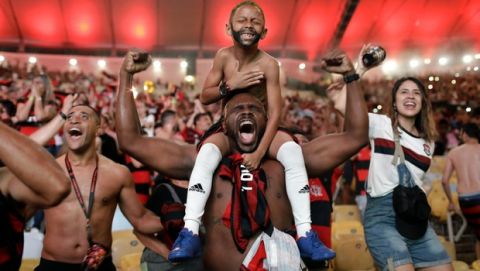 Flamengo soccer fans cheer a goal scored by Gabriel against Argentina's River Plate in the Copa Libertadores final match, broadcast on a giant screen at a watch party at the Macarena Stadium, in Rio de Janeiro, Brazil, Saturday, Nov. 23, 2019. The first single-match final will be played in front of more than 65,000 fans at Limas Monumental Stadium. The match was originally scheduled for Santiagos National Stadium, but it was moved because of street protests in Chile. (AP Photo/Silvia Izquierdo)
