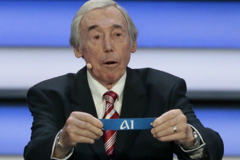 Former English soccer international Gordon Banks holds up the lot for the head of group A at the 2018 soccer World Cup draw in the Kremlin in Moscow, Friday, Dec. 1, 2017. (AP Photo/Ivan Sekretarev)