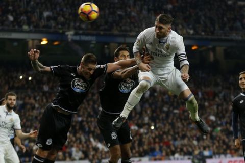 Real Madrid's Sergio Ramos, top, heads the ball to score the winning goal against Deportivo during a Spanish La Liga soccer match between Real Madrid and Deportivo Coruna at the Santiago Bernabeu stadium in Madrid, Saturday, Dec. 10, 2016. Ramos scored once on Real Madrid's 3-2 victory. (AP Photo/Francisco Seco)