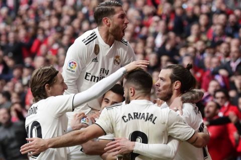 Real Madrid's Gareth Bale, right, celebrates with team mates after scoring his side's 3rd goal during a Spanish La Liga soccer match between Atletico Madrid and Real Madrid at the Metropolitano stadium in Madrid, Spain, Saturday, Feb. 9, 2019. (AP Photo/Manu Fernandez)