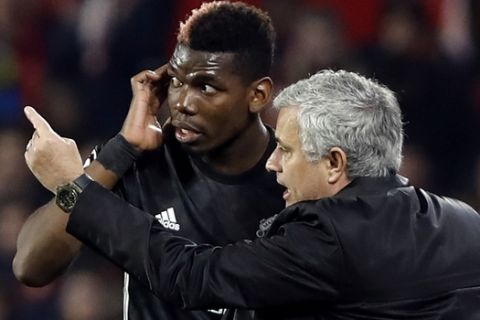 Manchester United manager Jose Mourinho, right, talks to Manchester United's Paul Pogba during the Champions League round of sixteen first leg soccer match between Sevilla FC and Manchester United at the Ramon Sanchez Pizjuan stadium in Seville, Spain, Wednesday, Feb. 21, 2018. (AP Photo/Miguel Morenatti)