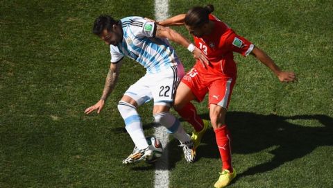 SAO PAULO, BRAZIL - JULY 01: Ricardo Rodriguez of Switzerland challenges Ezequiel Lavezzi of Argentina during the 2014 FIFA World Cup Brazil Round of 16 match between Argentina and Switzerland at Arena de Sao Paulo on July 1, 2014 in Sao Paulo, Brazil.  (Photo by Matthias Hangst/Getty Images)
