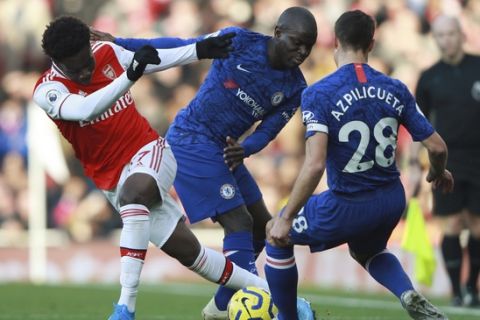 Arsenal's Bukayo Saka, left, is tackled by Chelsea's N'Golo Kante during the English Premier League soccer match between Arsenal and Chelsea, at the Emirates Stadium in London, Sunday, Dec. 29, 2019. (AP Photo/Ian Walton)