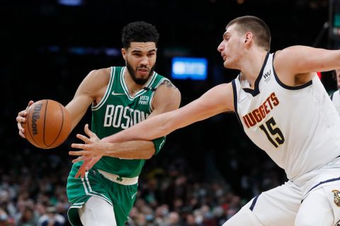 Boston Celtics' Jayson Tatum (0) drives against Denver Nuggets' Nikola Jokic (15) during the first half of an NBA basketball game Friday, Feb. 11, 2022, in Boston. (AP Photo/Michael Dwyer)