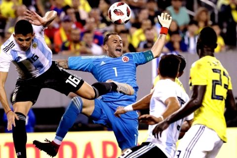 Colombia goalkeeper David Ospina, center, reacts after deflecting a pass intended for Argentina's Rodrigo Battaglia, left, during the second half of a international soccer friendly match, Tuesday, Sept. 11, 2018, in East Rutherford, N.J. The teams tied 0-0. (AP Photo/Julio Cortez)
