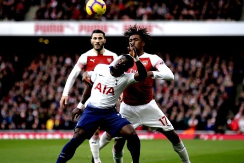 Tottenham's Serge Aurier, center, challenges for the ball with Arsenal's Sead Kolasinac, left, and Alex Iwobi during the English Premier League soccer match between Arsenal and Tottenham Hotspur at the Emirates Stadium in London, Sunday Dec. 2, 2018. (AP Photo/Tim Ireland)