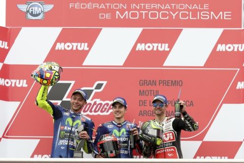 Spain's Maverick Vinales, center, celebrates at the podium his first place win, with second place winner and teammate Italy's Valentino Rossi, left, and third place finisher Great Britain's Cal Crutchlow, at the end of the MotoGP race of Argentina's Motorcycle Grand Prix at the Termas de Rio Hondo circuit in Argentina, Sunday, April 9, 2017.(AP Photo/Nicolas Aguilera)