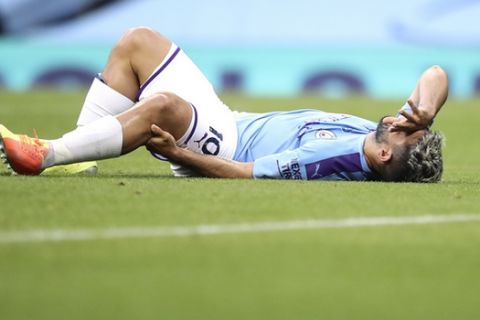 Manchester City's Sergio Aguero reacts as he lies on the pitch injured during the English Premier League soccer match between Manchester City and Burnley at Etihad Stadium, in Manchester, England, Monday, June 22, 2020. (AP Photo/Martin Rickett,Pool)