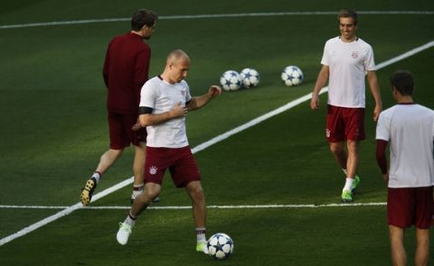 Bayern Munich's Arjen Robben, left, kicks the ball with teammates during a training session at the Santiago Bernabeu stadium in Madrid, Monday, April 17, 2017. Bayern Munich will play against Real Madrid a Champions League quarterfinal second leg soccer match on Tuesday 18. (AP Photo/Francisco Seco)