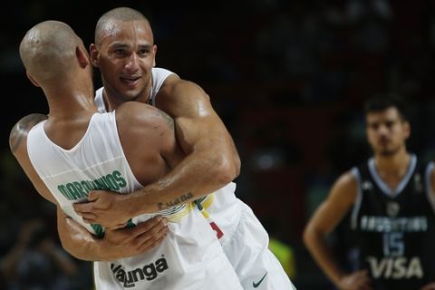 Brazil's Marquinhos Vieira, left, hugs Alex Garcia, second left, as they celebrates their victory during the Basketball World Cup  Round of 16 match between Brazil and Argentina in Madrid, Spain, Sunday, Sept. 7, 2014. The 2014 Basketball World Cup competition will take place in various cities in Spain from Aug. 30 through to Sept. 14. (AP Photo/Andres Kudacki)