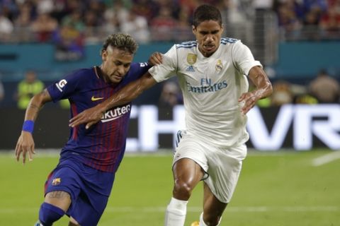 Barcelona's Neymar, left, and Real Madrid's Raphael Varane, right, go for the ball during the first half of an International Champions Cup soccer match, Saturday, July 29, 2017, in Miami Gardens, Fla. (AP Photo/Lynne Sladky)
