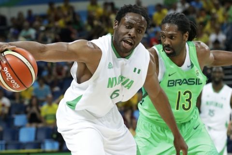 Nigeria's Ike Diogu (6) catches a pass in front of Brazil's Nene Hilario (13) during a basketball game at the 2016 Summer Olympics in Rio de Janeiro, Brazil, Monday, Aug. 15, 2016. (AP Photo/Charlie Neibergall)