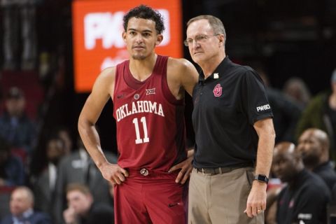 Oklahoma guard Trae Young, left, stands with head coach Lon Kruger, right, during the second half in an NCAA college basketball game against Arkansas during the Phil Knight Invitational Tournament, in Portland, Ore., Thursday, Nov. 23, 2017. (AP Photo/Troy Wayrynen)