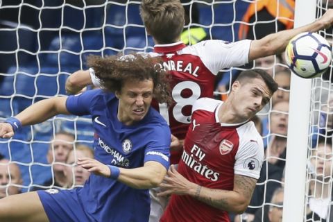 Chelsea's David Luiz, left, Arsenal's Granit Xhaka, right, and Arsenal's Nacho Monreal jump to head the ball during the English Premier League soccer match between Chelsea and Arsenal at Stamford Bridge stadium in London, Sunday, Sept. 17, 2017. (AP Photo/Tim Ireland)