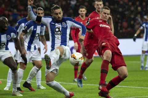 Leverkusen's Sven Bender, right, and Porto's Alex Telles, front, fight for the ball, during the Europa League round of 32 first leg soccer match between Bayer Leverkusen and Porto at the BayArena, Leverkusen, Germany, Thursday, Feb. 20, 2020. (Federico Gambarini/dpa via AP)