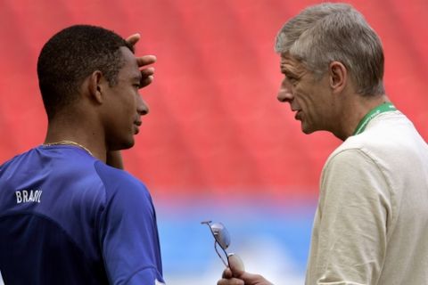 Arsene Wenger, right, coach of English soccer club Arsenal, talks to Arsenal's Brazilian player Gilberto Silva at the end of a training session of Brazil's national soccer team Tuesday, June 21, 2005, at the stadium in Cologne, Germany. Brazil will play Japan in their third game of the Confederations Cup Wednesday in Cologne. (AP Photo/Armando Franca)