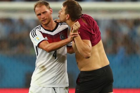 RIO DE JANEIRO, BRAZIL - JULY 13: A pitch invader tries to kiss Benedikt Hoewedes of Germany during the 2014 FIFA World Cup Brazil Final match between Germany and Argentina at Maracana on July 13, 2014 in Rio de Janeiro, Brazil.  (Photo by Clive Rose/Getty Images)
