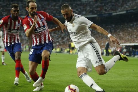 Real Madrid's Karim Benzema, right, vies for the ball with Atletico Madrid's Juanfran, centre, and Thomas Lemar during a Spanish La Liga soccer match between Real Madrid and Atletico Madrid at the Santiago Bernabeu stadium in Madrid, Spain, Saturday, Sept. 29, 2018. (AP Photo/Paul White)