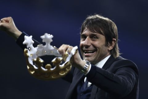 Chelsea's manager Antonio Conte laughs as he holds a toy crown after the English Premier League soccer match between Chelsea and Watford at Stamford Bridge stadium in London, Monday, May 15, 2017. Chelsea won the match 4-3. (AP Photo/Matt Dunham)