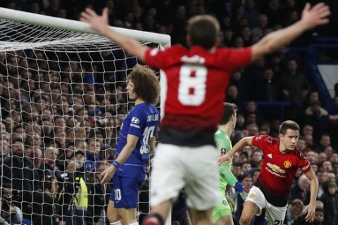 Manchester United's Ander Herrera, right, celebrates after passing Chelsea goalkeeper Kepa Arrizabalaga, in green, scoring the opening goal of the game during the English FA Cup fifth round soccer match between Chelsea and Manchester United at Stamford Bridge stadium in London, Monday, Feb. 18, 2019. Left is Manchester United's Juan Mata, celebrating, and center in blue is Chelsea's David Luiz. (AP Photo/Alastair Grant)