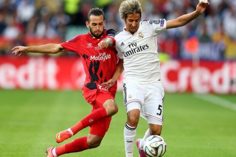 CARDIFF, WALES - AUGUST 12:  Aleix Vidal of Sevilla and Fabio Coentrao of Real Madrid compete for the ball during the UEFA Super Cup between Real Madrid and Sevilla FC at Cardiff City Stadium on August 12, 2014 in Cardiff, Wales.  (Photo by Clive Mason/Getty Images)