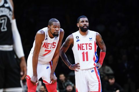 Brooklyn Nets' Kevin Durant (7) talks to Kyrie Irving (11) during the second half of an NBA basketball game against the San Antonio Spurs Monday, Jan. 2, 2023 in New York. The Nets won 139-103. (AP Photo/Frank Franklin II)