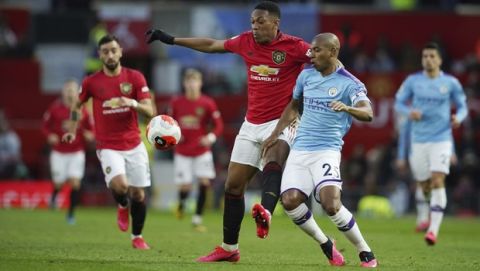 Manchester United's Anthony Martial, center, and Manchester City's Fernandinho compete for the ball during the English Premier League soccer match between Manchester United and Manchester City at Old Trafford in Manchester, England, Sunday, March 8, 2020. (AP Photo/Dave Thompson)