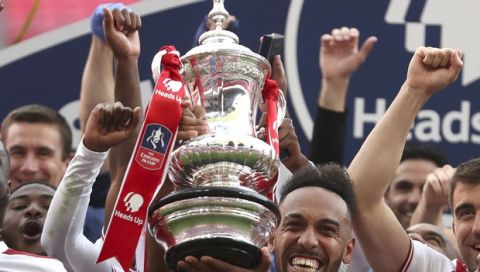 Arsenal's Pierre-Emerick Aubameyang holds the trophy celebrating with team mates players celebrate with the trophy after the FA Cup final soccer match between Arsenal and Chelsea at Wembley stadium in London, England, Saturday, Aug.1, 2020. (Catherine Ivill/Pool via AP)