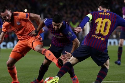 Barcelona forward Luis Suarez, center, and Barcelona forward Lionel Messi battle for the ball with Lyon midfielder Lucas Tousart during the Champions League round of 16, 2nd leg, soccer match between FC Barcelona and Olympique Lyon at the Camp Nou stadium in Barcelona, Spain, Wednesday, March 13, 2019. (AP Photo/Manu Fernandez)