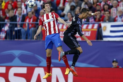 Real Madrid's Cristiano Ronaldo, right, competes for a high ball with Atletico's Diego Godin during a Champions League semifinal, 2nd leg soccer match between Atletico de Madrid and Real Madrid, in Madrid, Spain, Wednesday, May 10, 2017 . (AP Photo/Daniel Ochoa de Olza)