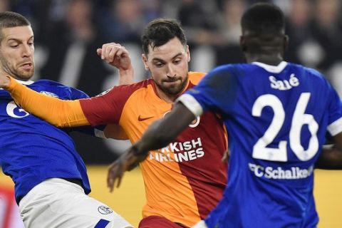 Schalke's Matija Nastasic, left, and Galatasaray's Sinan Gumus, center, and Schalke's Salif Sane, right, challenge for the ball during the Champions League group D soccer match between FC Schalke 04 and Galatasaray Istanbul in Gelsenkirchen, Germany, Tuesday, Nov. 6, 2018. (AP Photo/Martin Meissner)