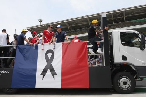 SAO PAULO, BRAZIL - NOVEMBER 15:  Lewis Hamilton of Great Britain and Mercedes GP and the other drivers are seen during drivers' parade with the french flag to honor the victims of the terrorist attacks in Paris prior to the Formula One Grand Prix of Brazil at Autodromo Jose Carlos Pace on November 15, 2015 in Sao Paulo, Brazil.  (Photo by Mark Thompson/Getty Images)