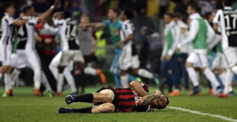 AC Milan's Davide Calabria lies on the pitch as Juventus players celebrate in background after Juventus' Medhi Benatia scored, during the Italian Cup final soccer match between Juventus and AC Milan, at the Rome Olympic stadium, Wednesday, May 9, 2018. (AP Photo/Gregorio Borgia)