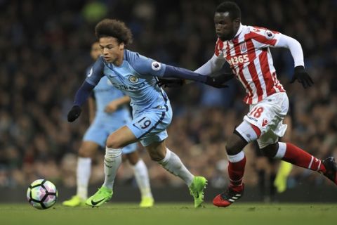 Manchester City's Leroy Sane, left, and Stoke City's Mame Biram Diouf battle for the ball during their English Premier League soccer match at the Etihad Stadium, Manchester, England, Wednesday, March 8, 2017. (Mike Egerton/PA via AP)