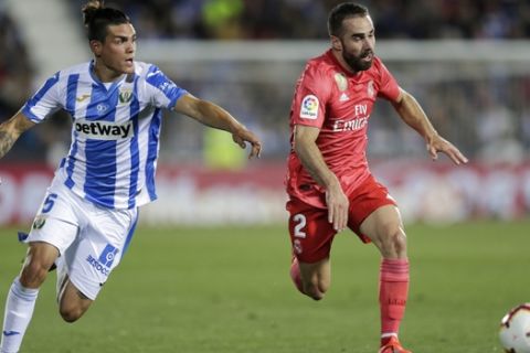 Real Madrid's Dani Carvajal, right, duels for the ball against Leganes' Jonathan Cristian Silva during a Spanish La Liga soccer match in Leganes, outskirts Madrid, Spain, Monday, April 15, 2019. (AP Photo/Bernat Armangue)