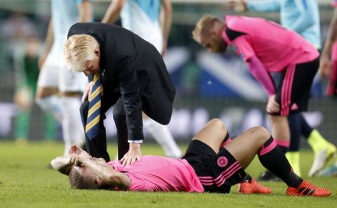 Scotland coach Gordon Strachan comforts Scotland's Leigh Griffiths, on the ground, after the World Cup Group F qualifying soccer match between Slovenia and Scotland, at the Stozice stadium in Ljubljana, Slovenia, Sunday, Oct. 8, 2017. (AP Photo/Darko Bandic)