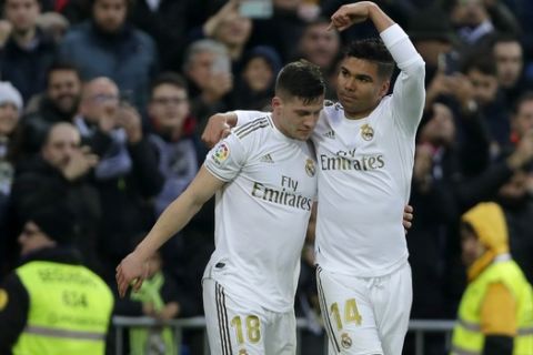 Real Madrid's Casemiro, right, celebrates with Real Madrid's Luka Jovic after scoring his side's opening goal during the Spanish La Liga soccer match between Real Madrid and Sevilla at Santiago Bernabeu stadium in Madrid, Saturday, Jan. 18, 2020. (AP Photo/Manu Fernandez)