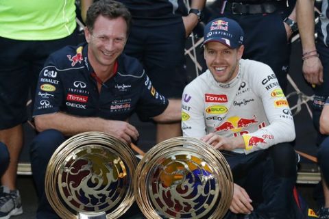 Red Bull driver Sebastian Vettel, right, of Germany and team principle Christian Horner pose for a photo after Vettel's win in the Korean Formula One Grand Prix at the Korean International Circuit in Yeongam, South Korea, Sunday, Oct. 6, 2013. (AP Photo/Aaron Favila)