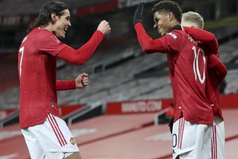 Manchester United's Marcus Rashford, right, celebrates with Edinson Cavani after scoring his side's second goal during the English FA Cup 4th round soccer match between Manchester United and Liverpool at Old Trafford in Manchester, England, Sunday, Jan. 24, 2021. (Martin Rickett/Pool via AP)