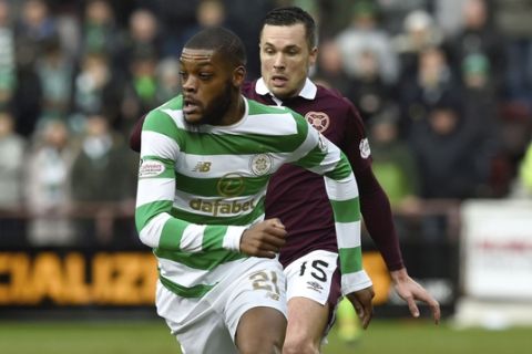 Celtic's Olivier Ntcham is chased down by Hearts Don Cowie during their Scottish Premiership soccer match at Tynecastle Stadium in Edinburgh, Scotland, Sunday Dec. 17, 2017.  Celtics record 69-match unbeaten run in Scottish soccer ended with a surprise thrashing on Sunday, when they lost 4-0 to Hearts, for its first defeat in any domestic competition since May 2016.(Ian Rutherford/PA via AP)