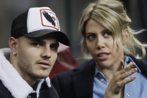 FILE - In this Thursday, Feb. 21, 2019, Inter Milan's Mauro Icardi is flanked by his wife Wanda Nara as they sit in the stands during the Europa League, round of 32, second leg soccer match between Inter Milan and SK Rapid Vienna, at the San Siro stadium in Milan, Italy. Mauro Icardi has been left off Inter Milans squad for Sundays match against Lazio following a six-week exile from the club. Icardi resumed training with Inter over the international break, having seemingly cleared up his differences with the club after being stripped of the captaincy amid protracted contract negotiations. So it was a surprise when Inter coach Luciano Spalletti announced Saturday that he now sees Icardi like a new player as he was out for so long. I still hold that he cant be ready yet to help his teammates so he wont be in the squad tomorrow. (AP Photo/Luca Bruno, File)
