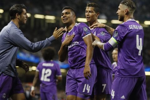 Real Madrid's Casemiro, left, celebrate with his teammates Cristiano Ronaldo, center and Sergio Ramos during the Champions League final soccer match between Juventus and Real Madrid at the Millennium Stadium in Cardiff, Wales, Saturday June 3, 2017. (AP Photo/Kirsty Wigglesworth)