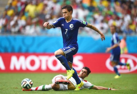 SALVADOR, BRAZIL - JUNE 25: Muhamed Besic of Bosnia and Herzegovina is tackled by Alireza Jahan Bakhsh of Iran during the 2014 FIFA World Cup Brazil Group F match between Bosnia-Herzegovina and Iran at Arena Fonte Nova on June 25, 2014 in Salvador, Brazil.  (Photo by Lars Baron - FIFA/FIFA via Getty Images)