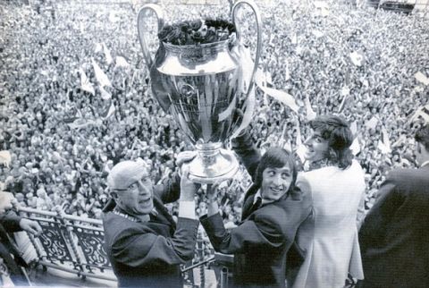 PKT2984 - 203504
FOOTBALLER - JOHAN CRUYFF

1971

Amsterdam: Burgomaster I. Smaklden of Amsterdam and  Johan Cruyff holding the cup high to show it to the fans. At right, Ruud Krol who, injured, could'nt take part in the fight, but as he belongs to the team as any other shared the cheers of the supporters.