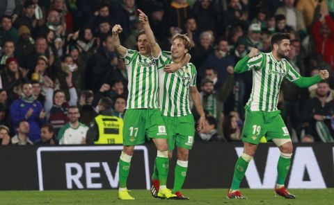 Betis' Canales, centre, celebrates with teammate, Joaquin Sanches, after scoring during La Liga soccer match between Betis and Real Madrid at the Villamarin stadium in Seville, Spain, Sunday, January 13, 2019. (AP Photo/Miguel Morenatti)