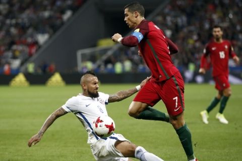 Chile's Arturo Vidal, left, tackles Portugal's Cristiano Ronaldo during the Confederations Cup, semifinal soccer match between Portugal and Chile, at the Kazan Arena, Russia, Wednesday, June 28, 2017. (AP Photo/Pavel Golovkin)