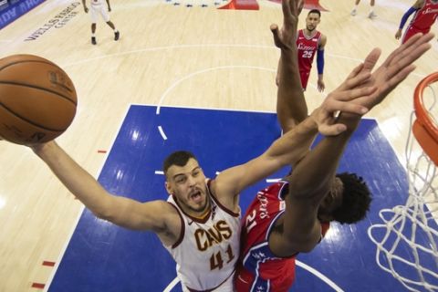 Cleveland Cavaliers' Ante Zizic, left, of Croatia, goes up for the shot against Philadelphia 76ers' Joel Embiid, right, of Cameroon, during the second half of an NBA basketball game, Tuesday, March 12, 2019, in Philadelphia. The 76ers won 106-99. (AP Photo/Chris Szagola)